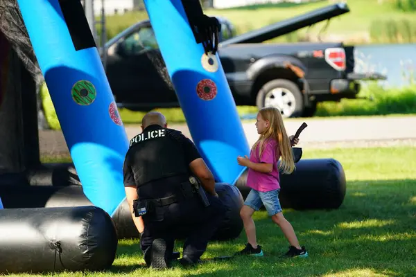 Tomah, Wisconsin ABD - 5 Ağustos 2025: Yerel Polis, Şerif ve İtfaiyeci memurlar, Ulusal Gece Gezisi Aile Eğlencesi etkinliği için cemaat aileleriyle bir araya geldi.