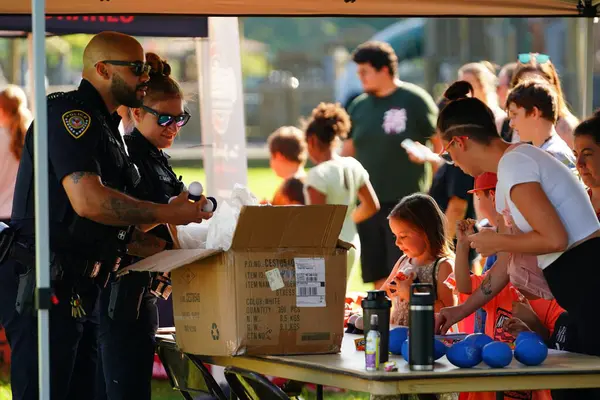 Tomah, Wisconsin ABD - 5 Ağustos 2025: Yerel Polis, Şerif ve İtfaiyeci memurlar, Ulusal Gece Gezisi Aile Eğlencesi etkinliği için cemaat aileleriyle bir araya geldi.