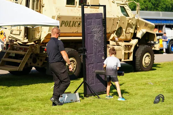 Tomah, Wisconsin ABD - 5 Ağustos 2025: Yerel Polis, Şerif ve İtfaiyeci memurlar, Ulusal Gece Gezisi Aile Eğlencesi etkinliği için cemaat aileleriyle bir araya geldi.