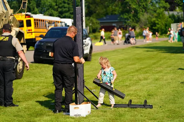 Tomah, Wisconsin ABD - 5 Ağustos 2025: Yerel Polis, Şerif ve İtfaiyeci memurlar, Ulusal Gece Gezisi Aile Eğlencesi etkinliği için cemaat aileleriyle bir araya geldi.