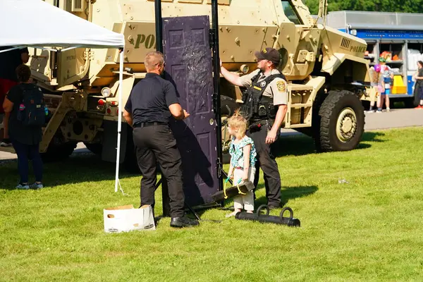 Tomah, Wisconsin ABD - 5 Ağustos 2025: Yerel Polis, Şerif ve İtfaiyeci memurlar, Ulusal Gece Gezisi Aile Eğlencesi etkinliği için cemaat aileleriyle bir araya geldi.