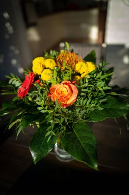 Masanın üzerinde renkli bir buket çiçek var.