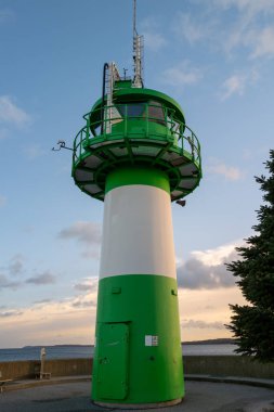the green-white lighthouse in the harbor of Luebeck Travemuende