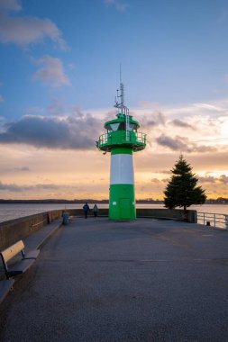 the green-white lighthouse in the harbor of Luebeck Travemuende