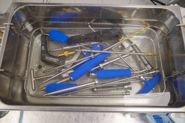 Ultrasonik banyoda çeşitli cerrahi aletler temizleniyor.