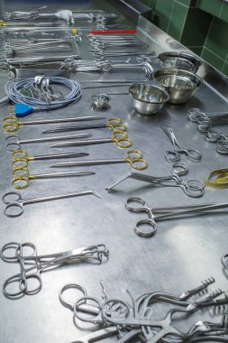 many different cleaned instruments for performing vascular surgery lie on a metal table