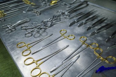 many different cleaned instruments for performing vascular surgery lie on a metal table