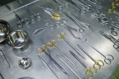 many different cleaned instruments for performing vascular surgery lie on a metal table