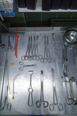 many different cleaned instruments for performing vascular surgery lie on a metal table