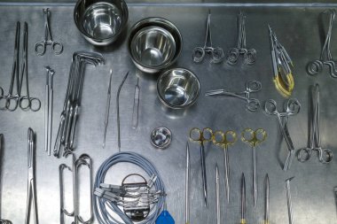 many different cleaned instruments for performing vascular surgery lie on a metal table