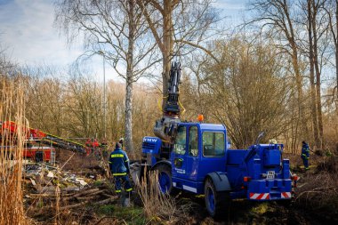 Members of THW remove construction debris with the help of a wheeled excavator  in Schoenberg, Germany