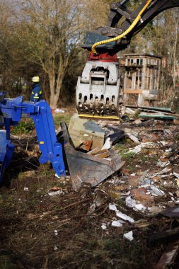 Members of THW remove construction debris with the help of a wheeled excavator  in Schoenberg, Germany