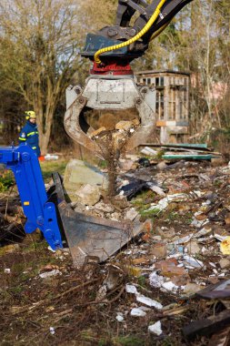 Members of THW remove construction debris with the help of a wheeled excavator  in Schoenberg, Germany