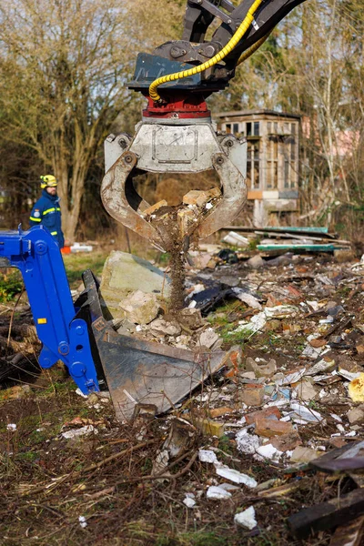 Members of THW remove construction debris with the help of a wheeled excavator  in Schoenberg, Germany