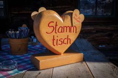 on a heart carved from wood is the german word Stammtisch
