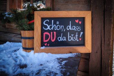 on a sign it says in german words : schoen, dass du da bist