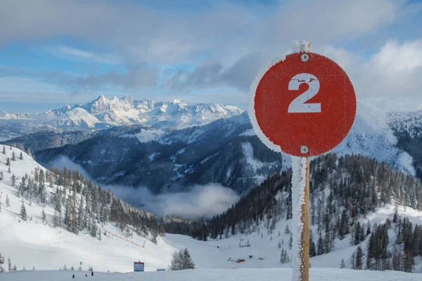 an icy red sign marks a red slope in the ski area