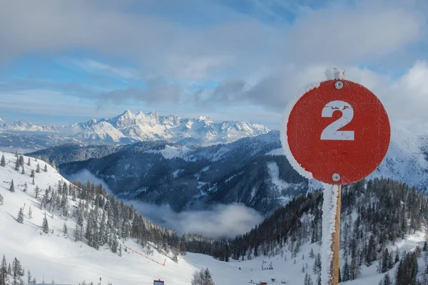 an icy red sign marks a red slope in the ski area