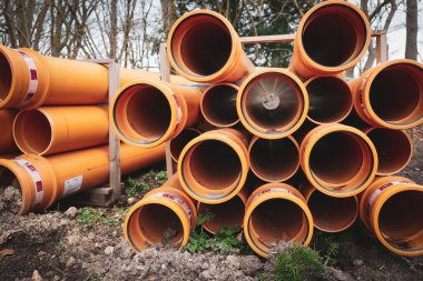 Bir inşaat sahasında bir sürü büyük boru bulunur.