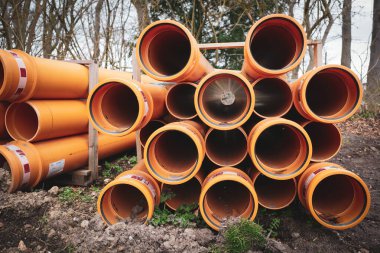 Bir inşaat sahasında bir sürü büyük boru bulunur.