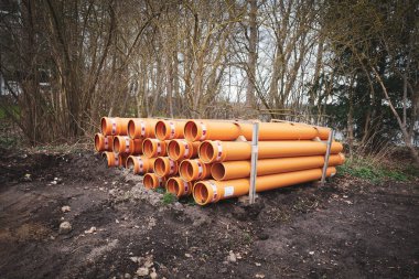 Bir inşaat sahasında bir sürü büyük boru bulunur.