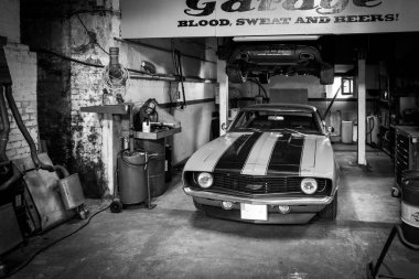 Eski bir Cheverolet atölyede duruyor.