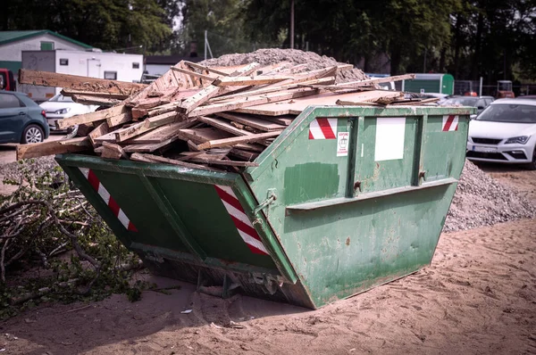 緑の廃棄物容器の建設現場では多くの木くずが回収され — ストック写真