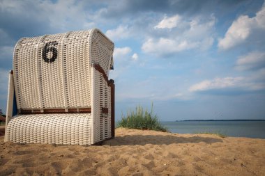 Baltık Denizi 'nin kenarında beyaz bir plaj sandalyesi var.