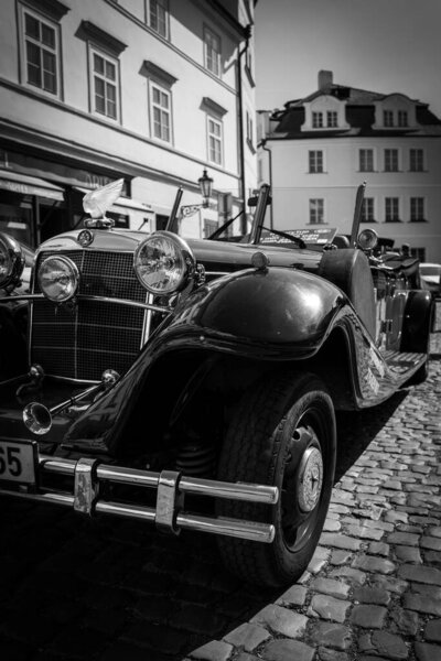 a historical oldtimer stands on a street with cobblestones
