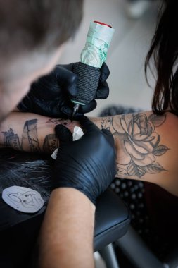 Bir koluna yeni bir dövme kazınmış.