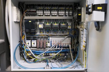 Bir endüstriyel makineyi kontrol etmek için fünye, frekans dönüştürücü ve terminal bantlı bir anahtar dolabında.