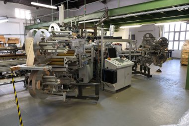 Bir fabrika salonunda karmaşık bir makine duruyor. 