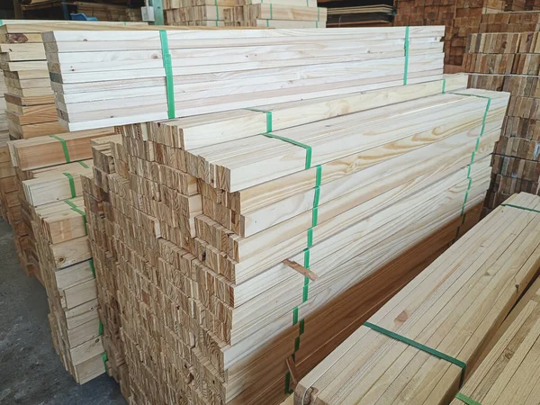 Stock pine wood log in furniture factory. Piles of wooden boards in sawmill. Warehouse for sawing boards for sale, inside a building. Wood timber stack of blanks construction material industry