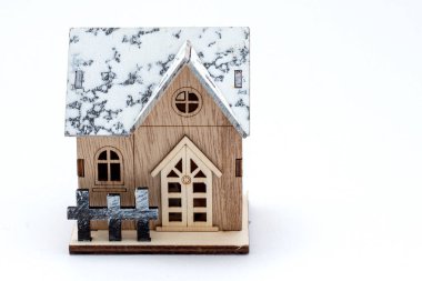 Winter style model wooden house with snow on roof, wooden fence, door and window. Vintage wood home for decoration. Toy small property model isolated on white background. concept home buyer-selle
