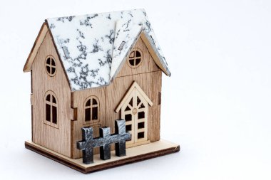 Winter style model wooden house with snow on roof, wooden fence, door and window. Vintage wood home for decoration. Toy small property model isolated on white background. concept home buyer-selle