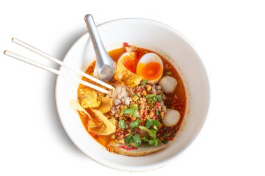 Tom Yum Kung Noodle beyaz arka planda izole edilmiş baharatlı acı biber çorbası ile. Tayland yemeği lezzetli sıcak ve iştah açıcı malzeme, limon, yumurta, et. Anında erişteli domuz köftesi, üst manzara.
