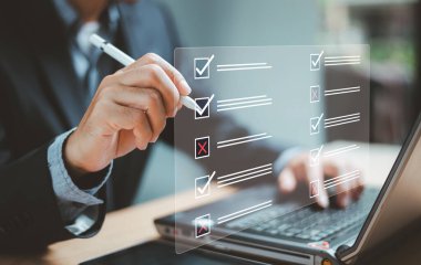 Belge yönetim sistemi DMS. İş değerlendirme formu, anket, kontrol listesi denetleme görev formu. İşadamı dizüstü bilgisayar kontrol listesi üzerinde çalışıyor ve araştırma formunu internette dolduruyor. Yanlış ve doğru.