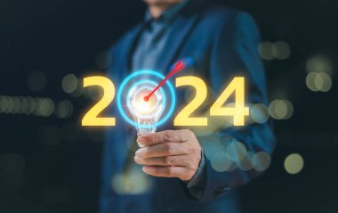 Takvim 2024 'e başla. İş adamı, 2024 stratejisi ile hafif blub 'u ve hareket hedefi iş trendini gösteriyor. Yeni yıl 2024, dijital pazarlama ve kar geliri hedefleyen kişi