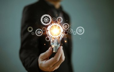 Fikir yeniliği ve ilham konsepti. Yenilikçi dijital çözüm teknolojisi. Beyin fırtınası yaratıcılık, fikir üretme. İş adamı ampul dişli sembolü, bilgi çevrimiçi ağ teknolojisi kullanıyor
