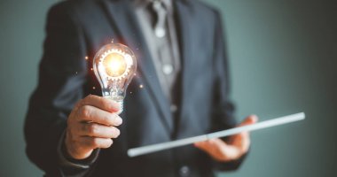 Fikir bilgisi ve eğitim çözüm konsepti. Yenilikçi dijital teknoloji. Beyin fırtınası yaratıcılığı, iş adamıyla düşünme fikri ampul ikonu tutuyor. Sürdürülebilir iş için ilham fikri