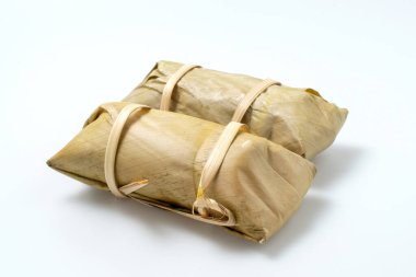 Muz yaprağında yapış yapış pirinçli muz ya da beyaz zemin üzerinde Khao Tom Mud izole. Geleneksel Tayland yemeği tarzı, muz yaprağında buğulanmış glutinous pilavı (Khao Tom Mat, Khao Tom Pad) hasır sepette