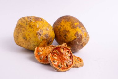 Beyaz arka planda izole edilmiş kuru Bael Fruit çayı (Aegle marmelos). Sarı Bael meyvesi yarısı ve yaz duvar kâğıdı için dolu. Doğa ağacı çayı ya da sebze suyu ve bitkisel ilaçlar. Tropik tatlı bitki
