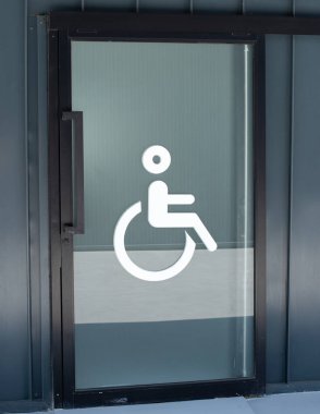 Tuvalet levhası devre dışı, WC. Tekerlekli sandalye tuvalet beyaz ikonu beyaz duvar zemininde. Kapıdaki beyaz adam tabelası. Havaalanı veya benzin istasyonu otobüslerinde insanlar için hijyen tuvaleti