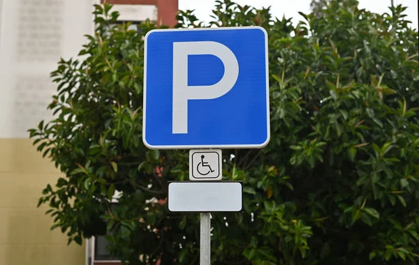 Disabled parking lot traffic sign. Street symbol with a wheelchair. Extra place to park a car for people that are handicapped. This place is the most accessible area to park a car.