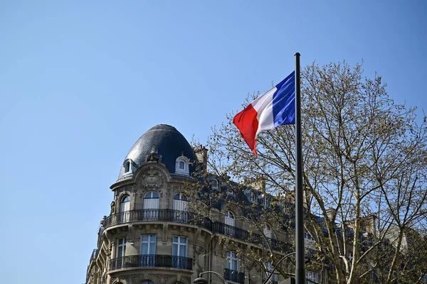 The French flag, fluttering in the wind, with its three vertical stripes of blue, white, and red, is a proud and patriotic symbol of the French Republic.