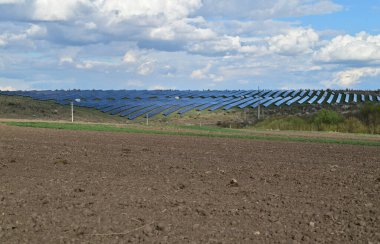 Solar panels in the middle of a field providing energy production in agriculture. clipart