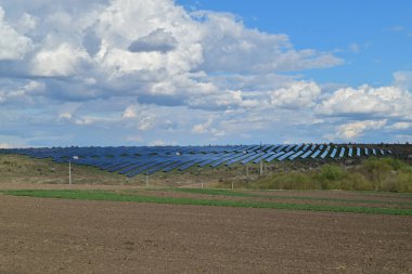 Solar panels in the middle of a field providing energy production in agriculture. clipart