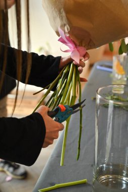 Eller dikkatlice çiçekleri buket kurarken makasla keser..