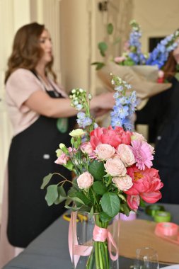 Bitmiş çiçek buketleri atölye sırasında bir vazoda sergilenir.