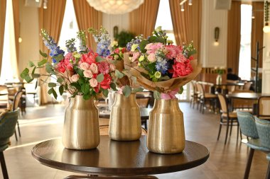 Bitmiş çiçek buketleri atölye sırasında bir vazoda sergilenir.